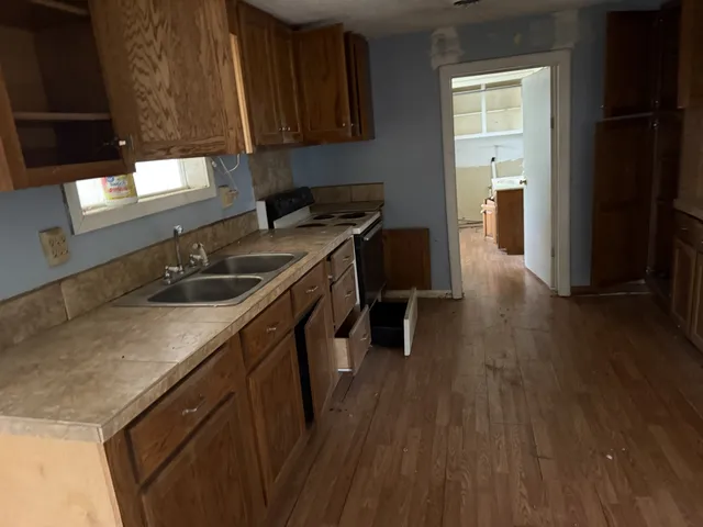 a kitchen with sink cabinets and wooden floor