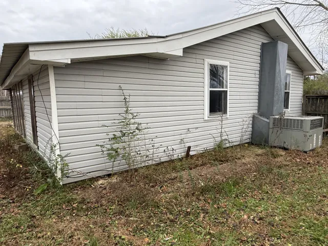 a view of a small white house with a small yard