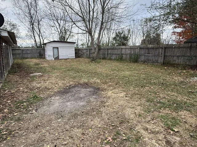 a white house that has tree in front of it