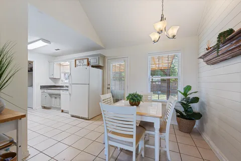 a dining room with furniture a kitchen island and stainless steel appliances