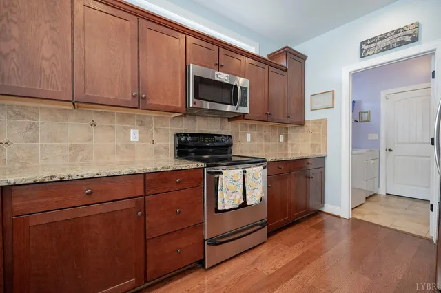 a kitchen with stainless steel appliances granite countertop a stove a sink and a microwave