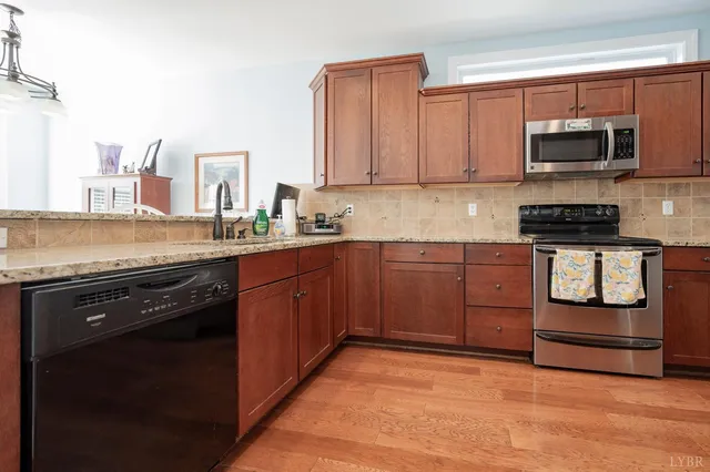 a kitchen with stainless steel appliances granite countertop a stove a sink and a microwave