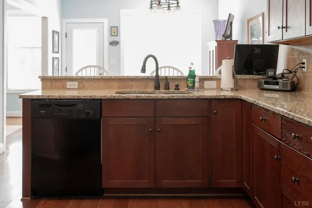 a kitchen with granite countertop a sink stainless steel appliances and cabinets
