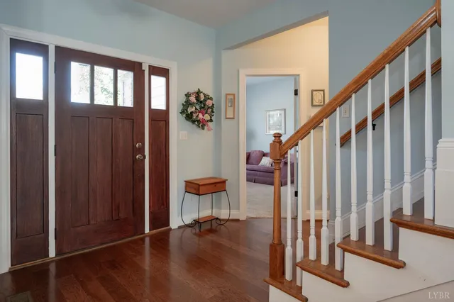 a view of a hallway with wooden floor and staircase