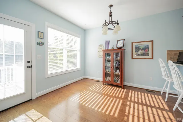 a view of a bedroom with wooden floor and windows