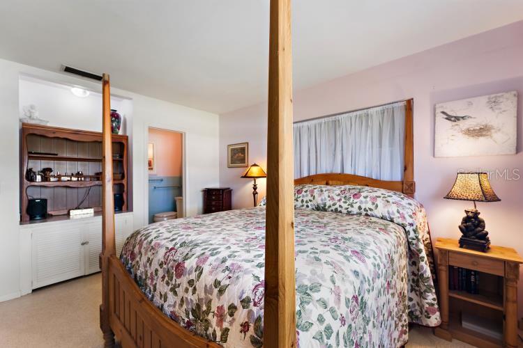 444 Driftwood Road Venice, FL 34293 - Photo 23 of 27 a bedroom with a large bed and a dresser