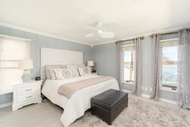 a bedroom with a bed and a large window