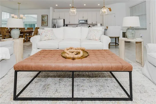 a living room with furniture and a dining table with kitchen view
