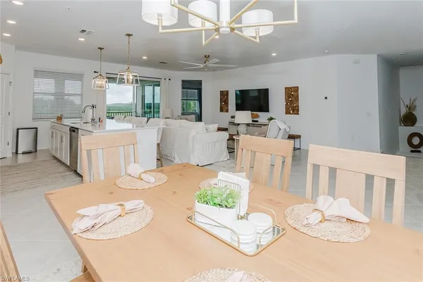 a living room with furniture a flat screen tv and kitchen view