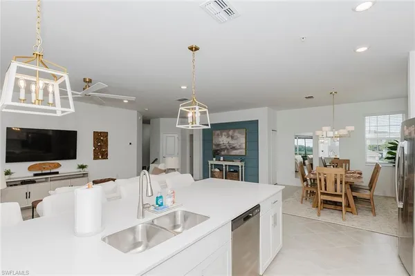 a kitchen with kitchen island granite countertop a sink and a wooden floor