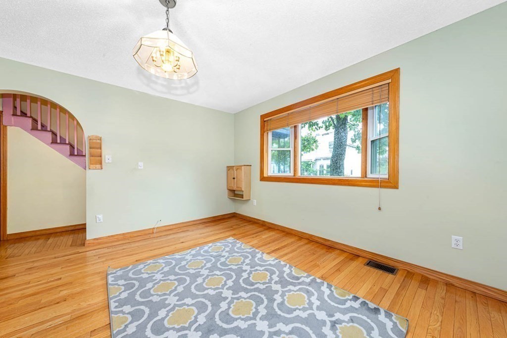 101 Reed Street Cambridge, MA 02140 - Photo 4 of 15 a view of an empty room with wooden floor and a window