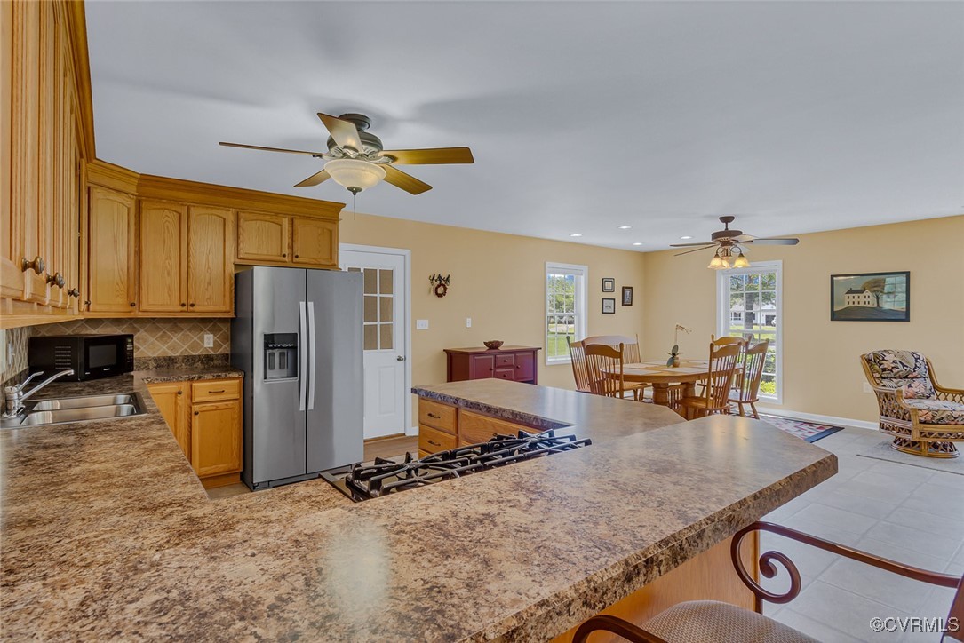 781 Coan Haven Road Lottsburg, VA 22511 - Photo 16 of 50 a kitchen with stainless steel appliances granite countertop a refrigerator a stove a sink a dining table and chairs with the view of living room