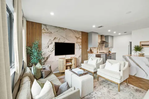 a living room with furniture a flat screen tv and a large window