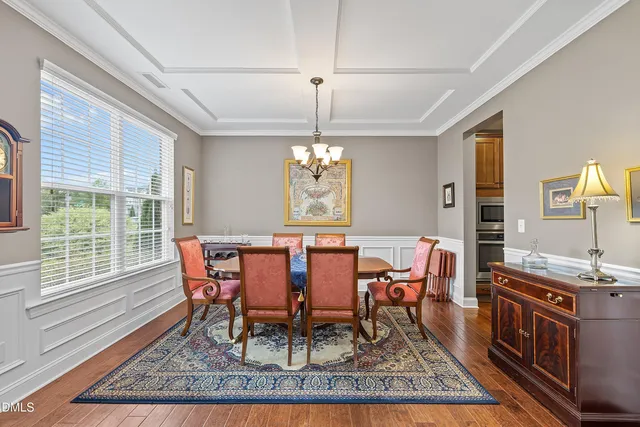 a kitchen with stainless steel appliances granite countertop a refrigerator a sink dishwasher a stove and white countertops with wooden floor