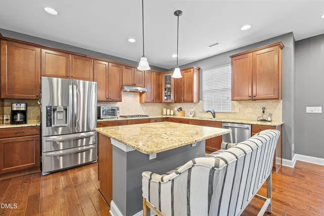 a kitchen with granite countertop a sink window and cabinets