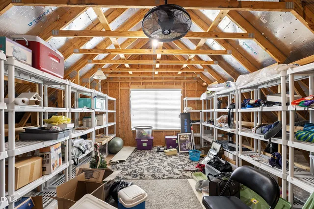 a view of swimming pool that has lawn chairs with plants and palm trees
