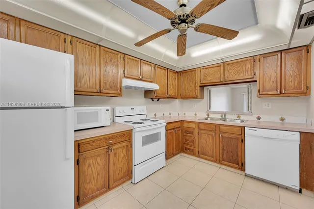 a kitchen with cabinets a sink and white appliances