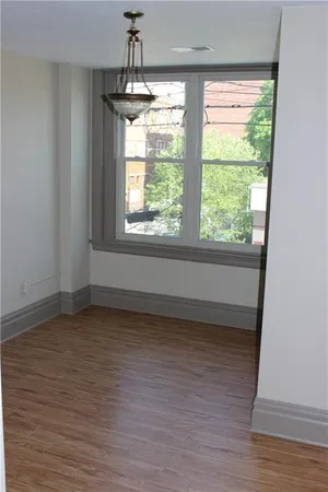 a view of a livingroom with wooden floor and a fireplace