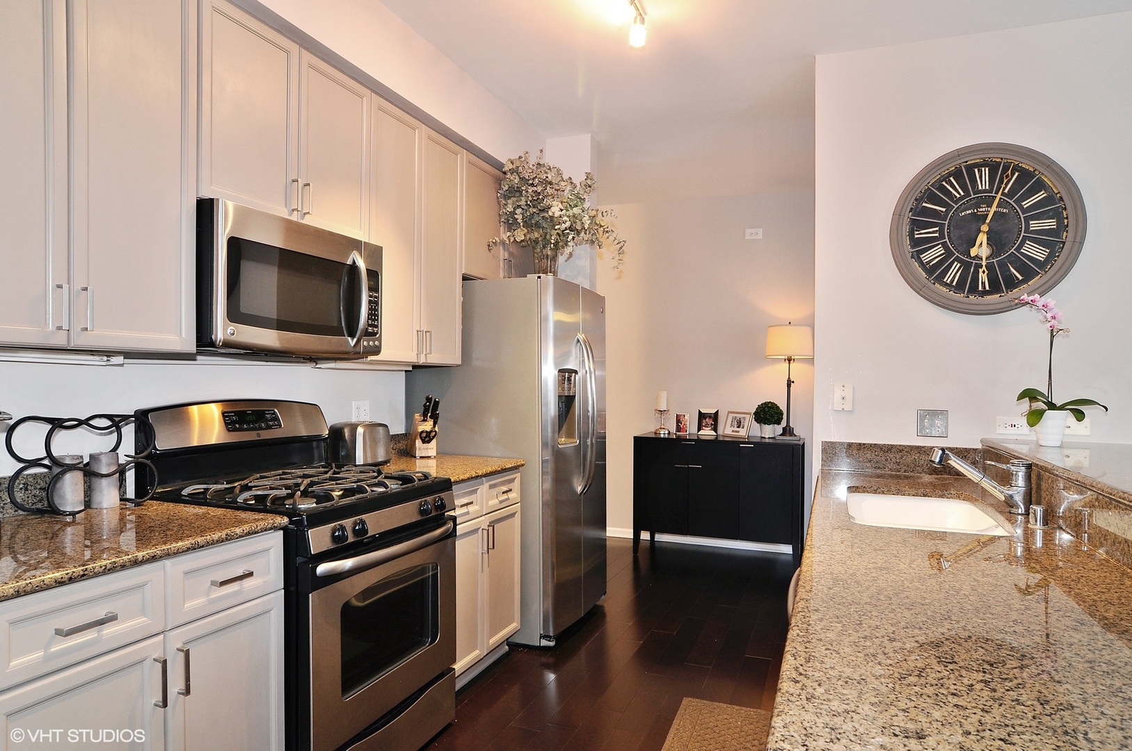 1122 North Dearborn Street, Unit 7A Chicago, IL 60610 - Photo 7 of 25 a kitchen with stainless steel appliances kitchen island granite countertop a stove a sink and a microwave
