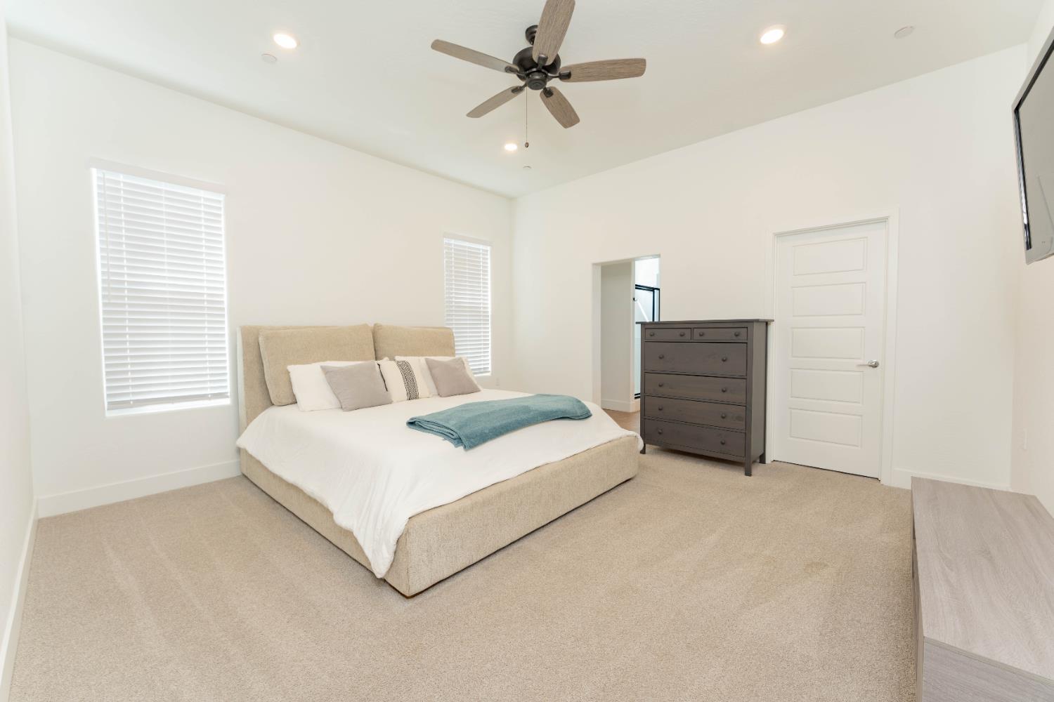 3811 North Santa Fe Street Visalia, CA 93291 - Photo 15 of 23 a spacious bedroom with a bed a dresser and a chandelier