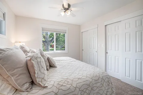 a bedroom with a bed a window and a painting on the wall