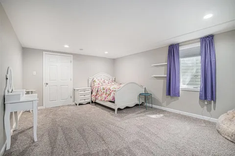 a bed sitting in a bedroom next to a window