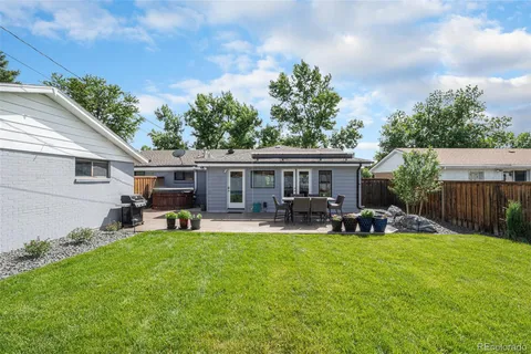 a view of a house with backyard sitting area and garden
