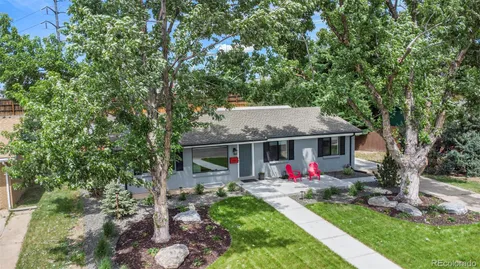a view of house with a big yard plants and large trees