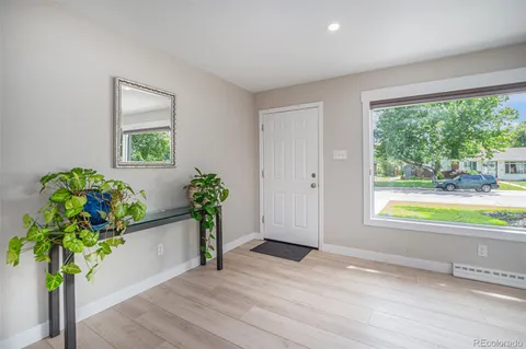 a living room with furniture a flat screen tv and a floor to ceiling window
