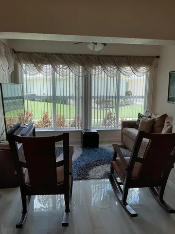 a living room with furniture and a floor to ceiling window