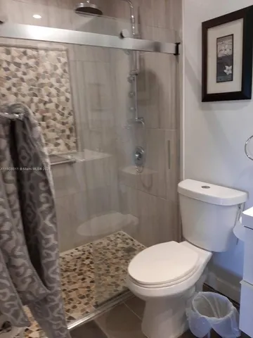 a bathroom with a toilet and a shower