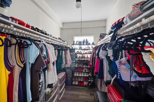a view of walk in closet with clothes and shoes