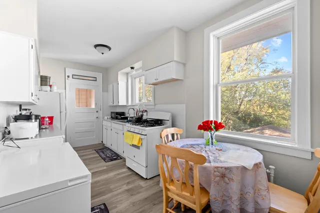 a very nice looking open dining room with kitchen island furniture a large window and kitchen view