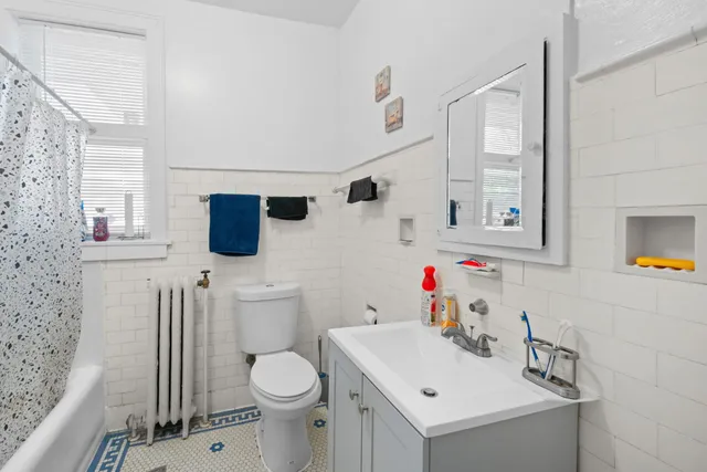 a bathroom with a sink mirror vanity and toilet