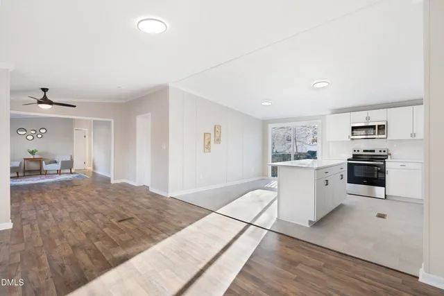 a open kitchen with white cabinets and white appliances