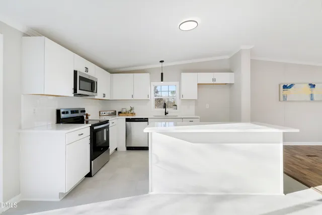 a kitchen with stainless steel appliances kitchen island sink stove and cabinets