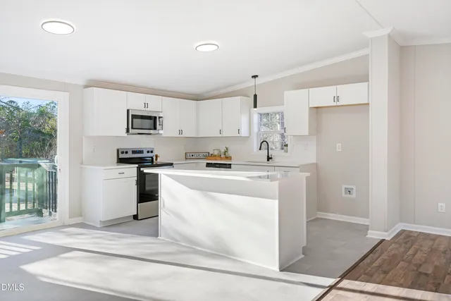 a kitchen with kitchen island a sink stainless steel appliances and cabinets