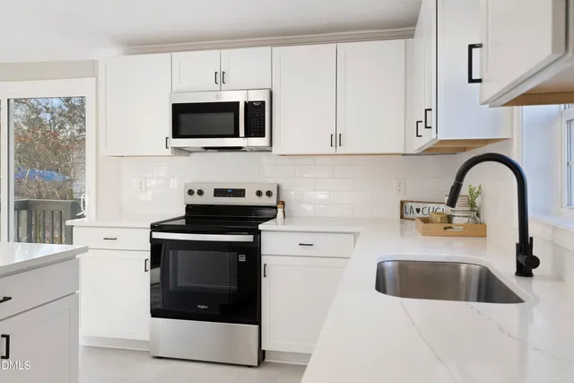 a kitchen with stainless steel appliances a stove a sink a microwave and cabinets