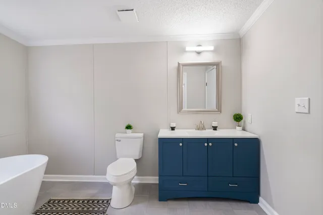 a bathroom with a toilet sink a mirror and vanity