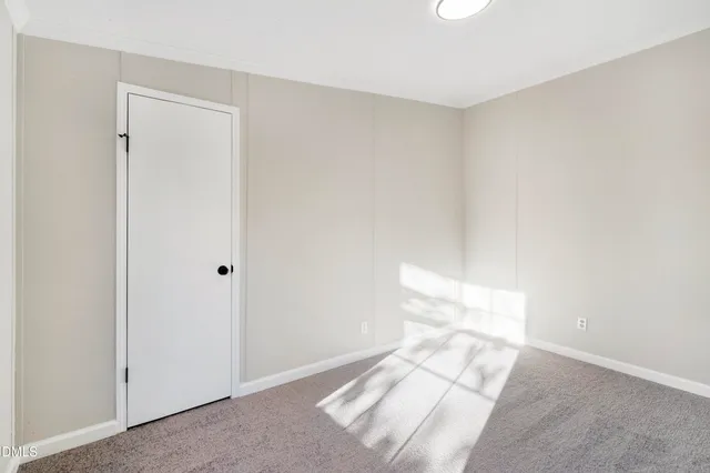 a view of a hallway with wooden floor and a living room