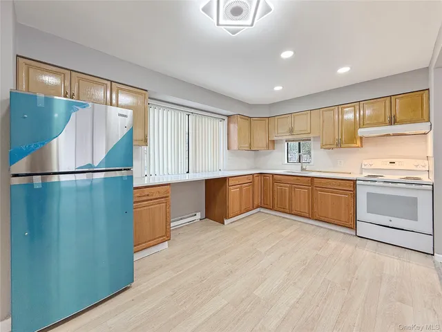 a kitchen with stainless steel appliances granite countertop a refrigerator a sink a stove with wooden floors