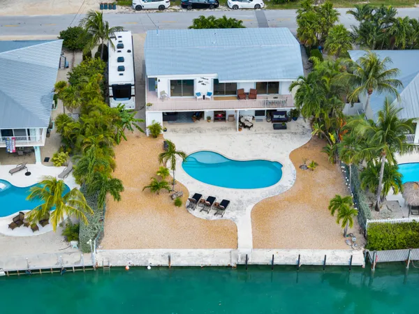 an aerial view of a house with swimming pool and garden
