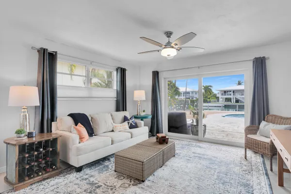 a living room with furniture ceiling fan and a large window