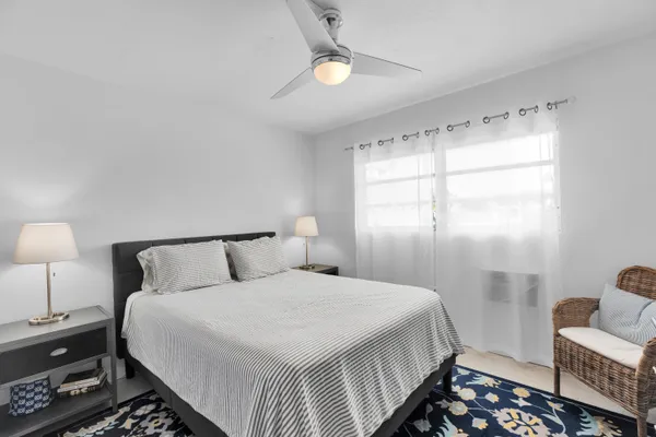 a bedroom with a bed and a lamp on the dresser