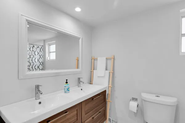 a bathroom with a toilet a sink a mirror and vanity