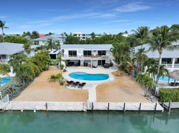 an aerial view of residential houses with outdoor space and swimming pool