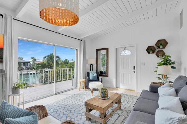a living room with furniture a lamp and a large window