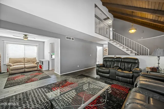 a room with furniture a flat screen tv and a floor to ceiling window