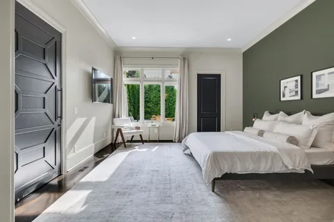 a spacious bedroom with a bed and a large window