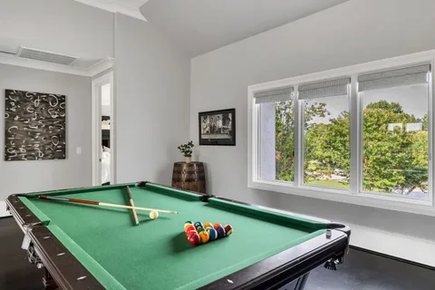a room with pool table and windows